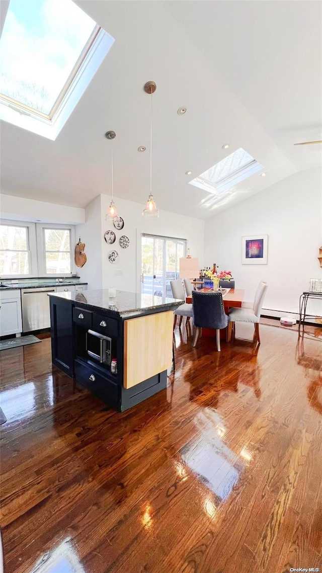 kitchen with dark hardwood / wood-style flooring, decorative light fixtures, stainless steel dishwasher, and vaulted ceiling with skylight