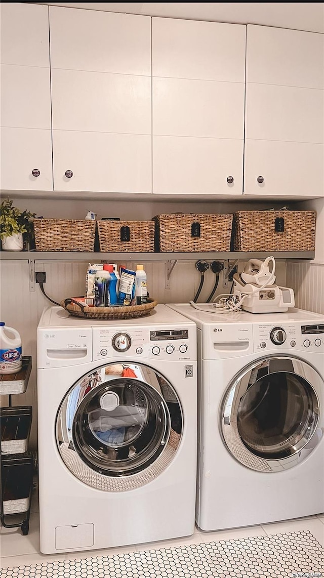 laundry area with separate washer and dryer, light tile patterned flooring, and cabinets