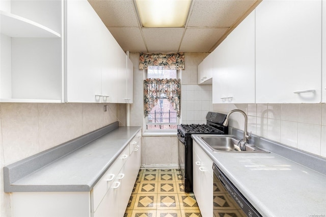 kitchen featuring a paneled ceiling, black appliances, sink, tasteful backsplash, and white cabinetry