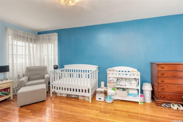 bedroom featuring a crib and hardwood / wood-style floors