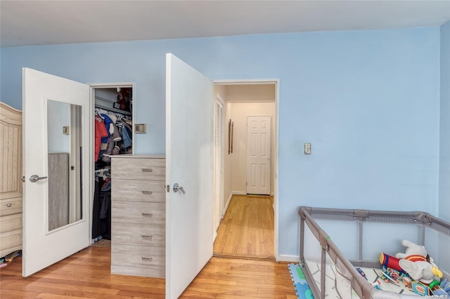 bedroom with light hardwood / wood-style floors and a closet