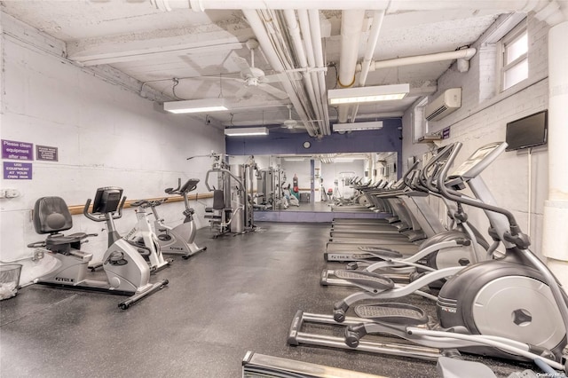 exercise room featuring ceiling fan and an AC wall unit