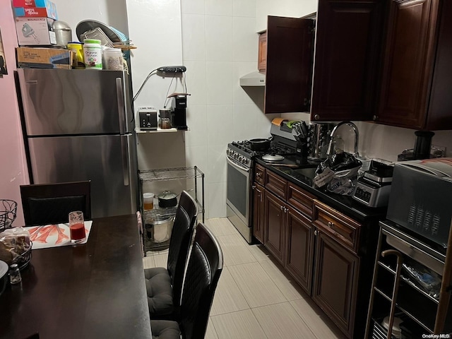 kitchen featuring sink, extractor fan, light tile patterned floors, tile walls, and appliances with stainless steel finishes