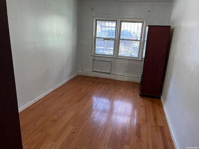 unfurnished room featuring light hardwood / wood-style flooring and baseboard heating