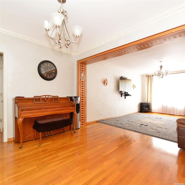 miscellaneous room featuring hardwood / wood-style flooring, a notable chandelier, and crown molding