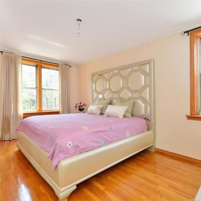 bedroom with hardwood / wood-style floors and crown molding