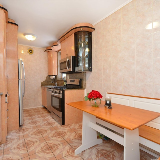 kitchen with decorative backsplash, ornamental molding, tile walls, and appliances with stainless steel finishes