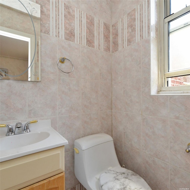 bathroom featuring vanity, tile walls, and toilet