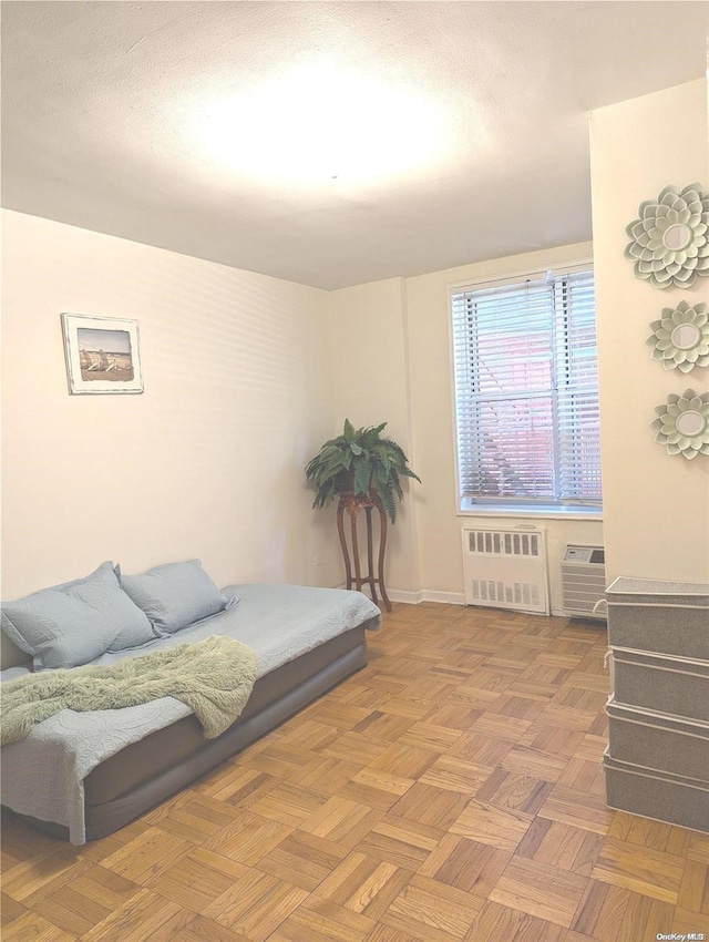 bedroom featuring radiator heating unit and parquet flooring