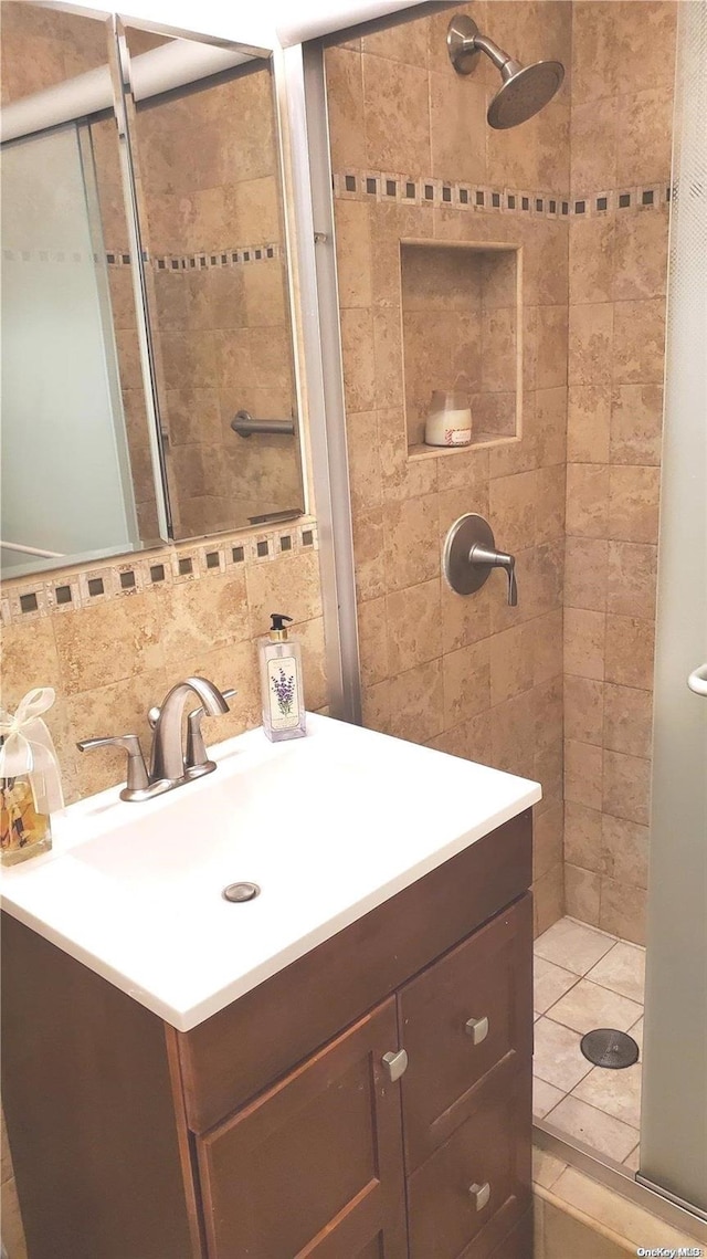 bathroom featuring a tile shower, decorative backsplash, and vanity