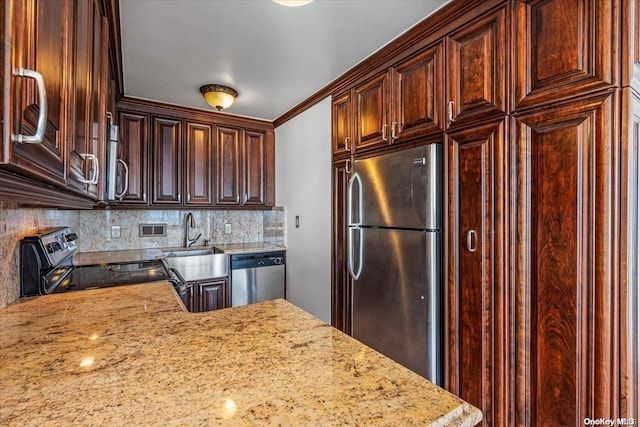 kitchen with light stone countertops, appliances with stainless steel finishes, decorative backsplash, crown molding, and sink