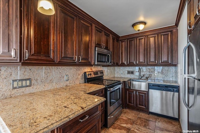 kitchen featuring sink, light stone countertops, tasteful backsplash, dark brown cabinets, and stainless steel appliances