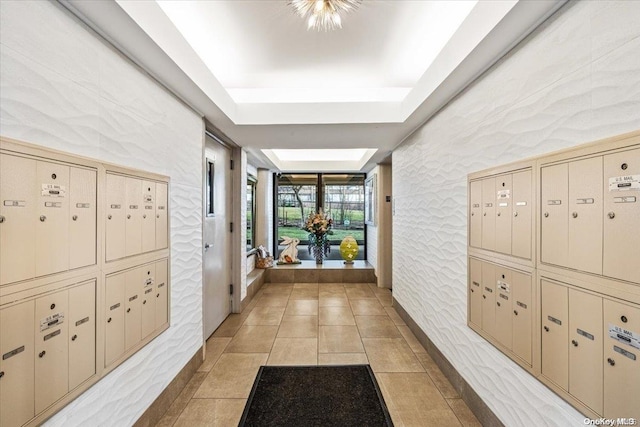 hallway featuring a raised ceiling and light tile patterned floors