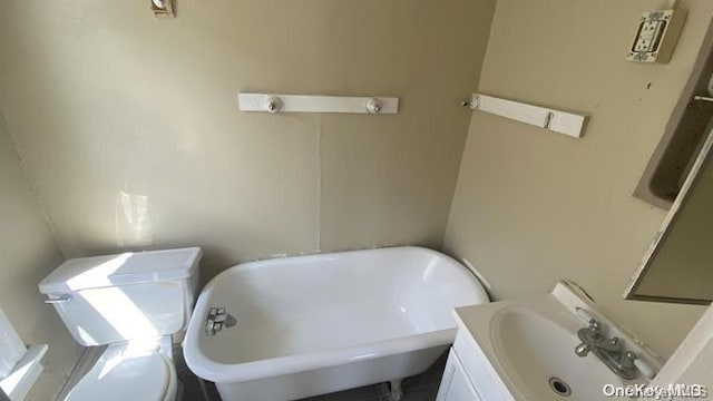 bathroom featuring vanity, toilet, and a washtub