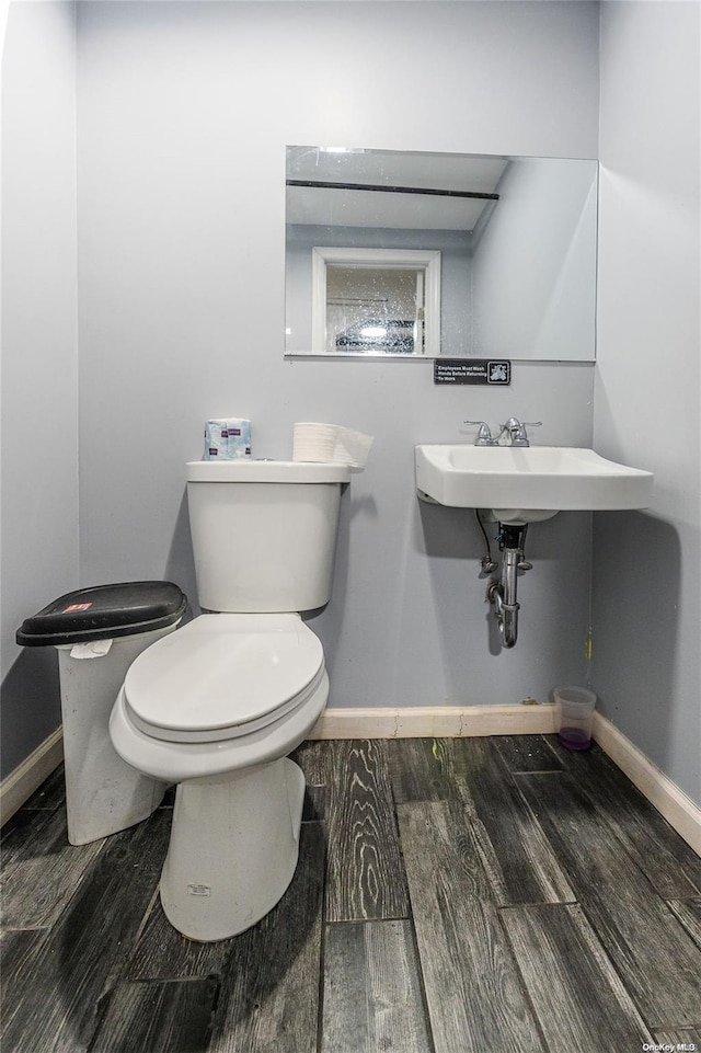 bathroom with sink, toilet, and hardwood / wood-style flooring