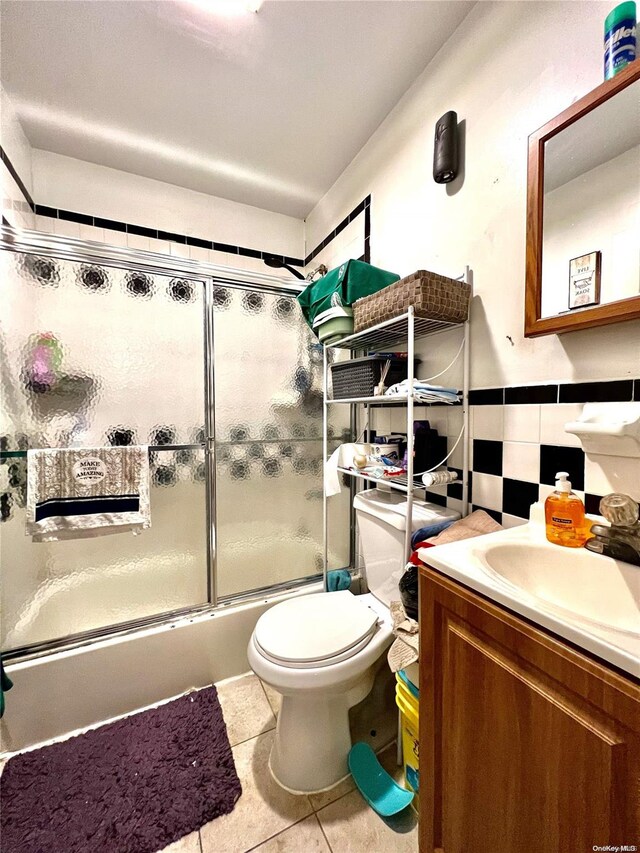 full bathroom featuring tile patterned floors, vanity, toilet, and shower / bath combination with glass door