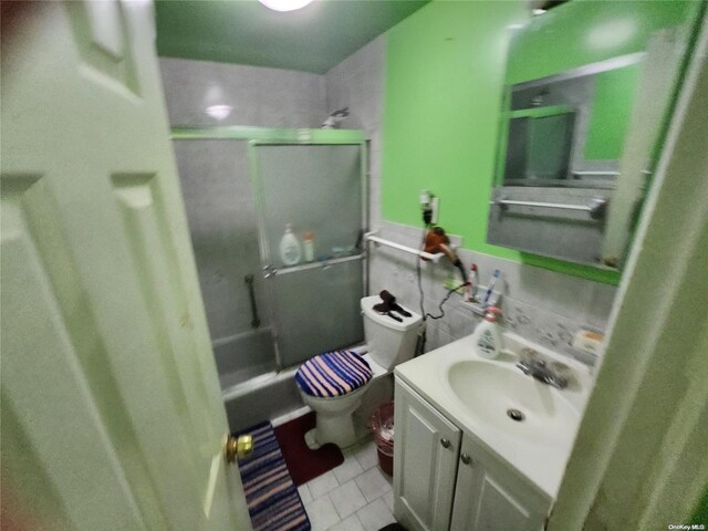 full bathroom with tile patterned floors, washtub / shower combination, vanity, and toilet