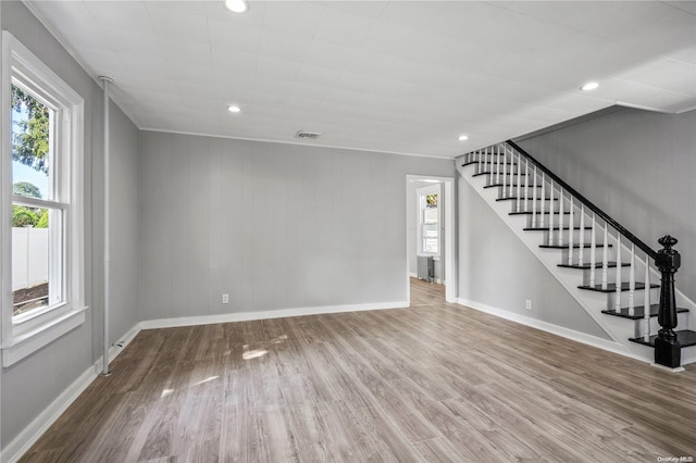 unfurnished living room featuring wood walls and wood-type flooring