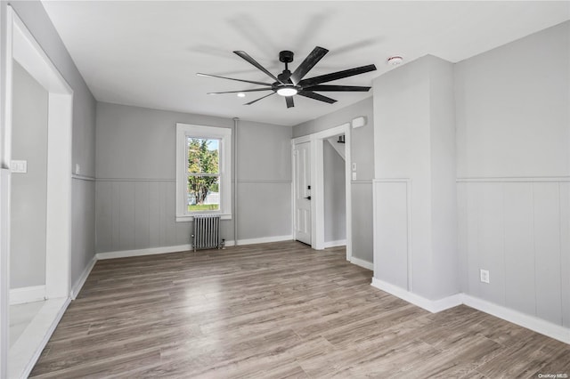 unfurnished bedroom featuring radiator, ceiling fan, and wood-type flooring