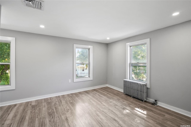 unfurnished room featuring hardwood / wood-style flooring and radiator