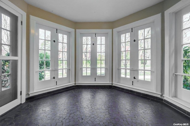 unfurnished sunroom with a wealth of natural light and french doors