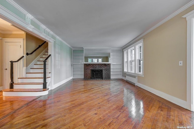 unfurnished living room with a fireplace, radiator heating unit, hardwood / wood-style floors, and ornamental molding