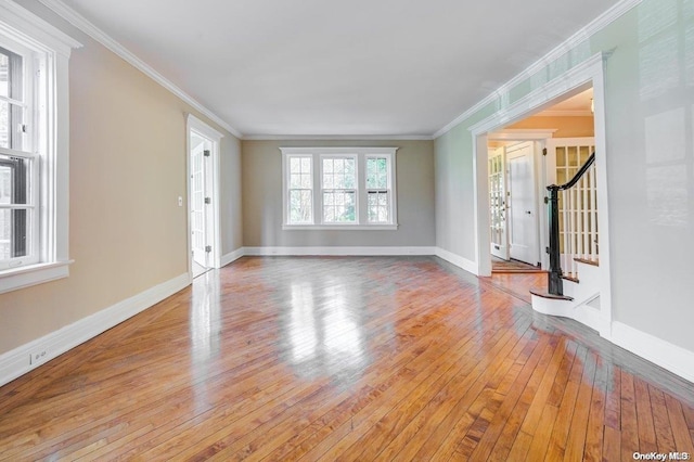 unfurnished living room featuring hardwood / wood-style flooring and crown molding