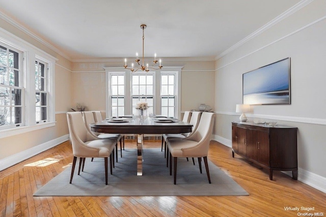 dining room with crown molding, light hardwood / wood-style flooring, and a chandelier