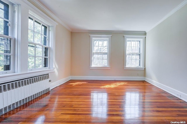 empty room with radiator, a wealth of natural light, and light hardwood / wood-style floors