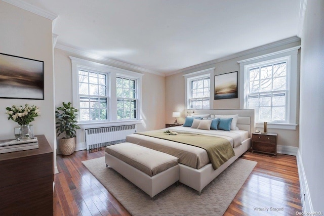 bedroom featuring radiator heating unit, dark hardwood / wood-style flooring, multiple windows, and crown molding