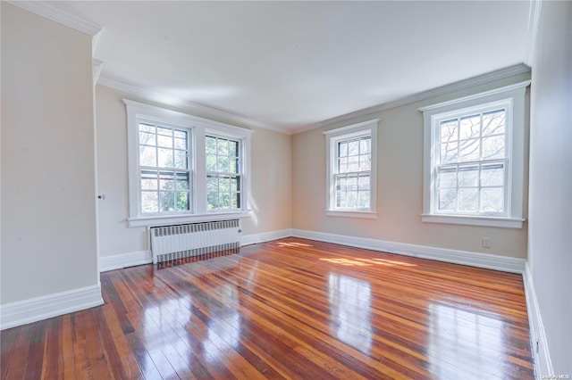 unfurnished room with radiator heating unit, dark hardwood / wood-style flooring, plenty of natural light, and ornamental molding