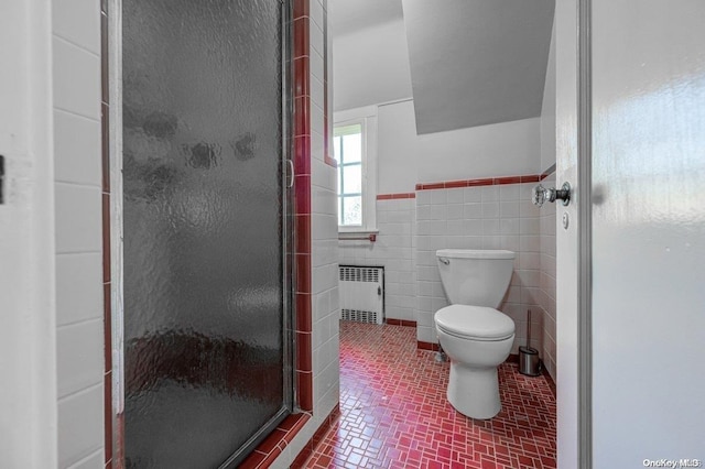 bathroom featuring toilet, an enclosed shower, tile walls, and radiator