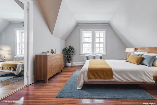 bedroom with radiator heating unit, lofted ceiling, and dark wood-type flooring