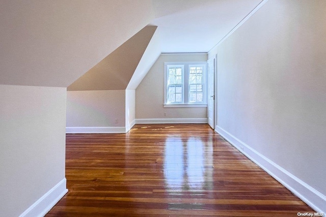 bonus room featuring dark wood-type flooring and vaulted ceiling