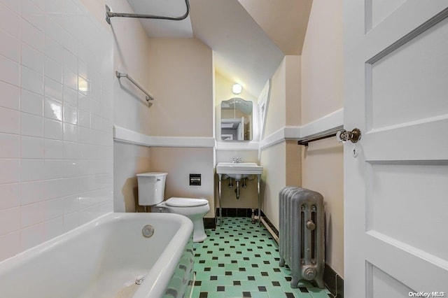 bathroom featuring toilet, radiator heating unit, and a tub