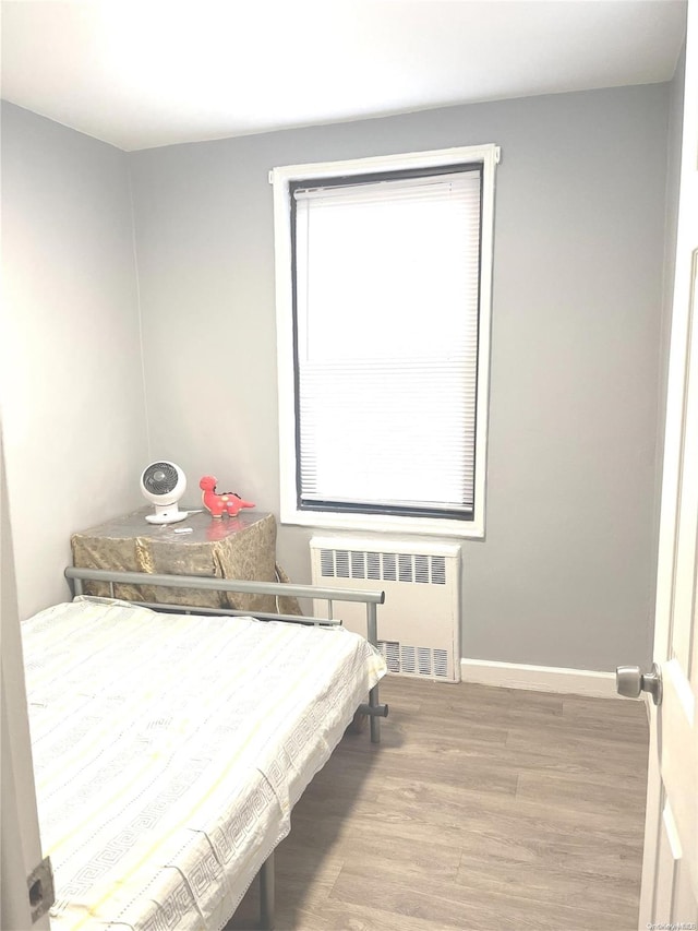 bedroom featuring wood-type flooring and radiator