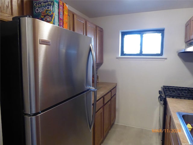 kitchen with ventilation hood, sink, and stainless steel appliances