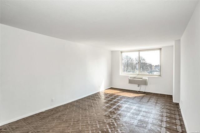 empty room with a textured ceiling and a wall mounted air conditioner