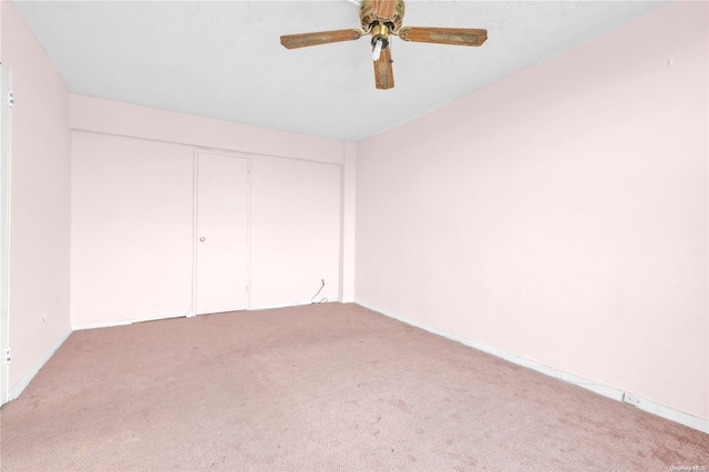 unfurnished bedroom with ceiling fan, light carpet, and a closet