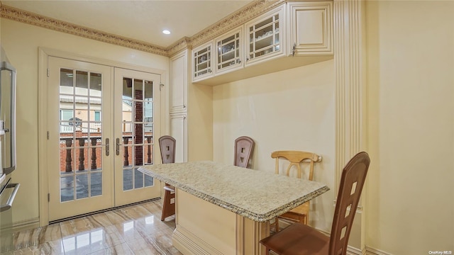 kitchen with cream cabinets, a breakfast bar area, and french doors