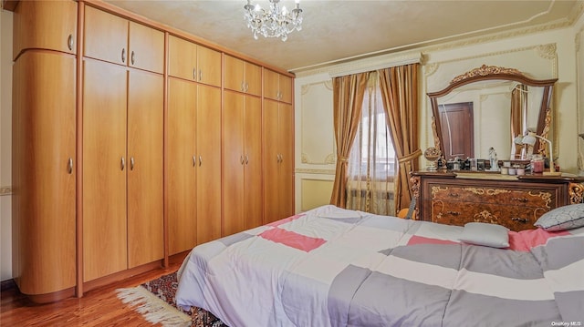 bedroom with light wood-type flooring and a notable chandelier