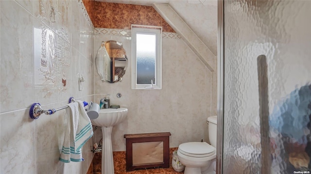 bathroom with toilet, tile walls, and vaulted ceiling