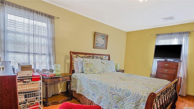 bedroom with hardwood / wood-style floors and multiple windows