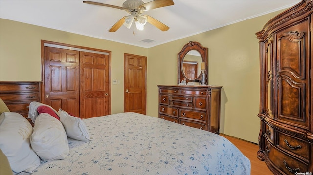 bedroom with light wood-type flooring, a closet, ceiling fan, and ornamental molding