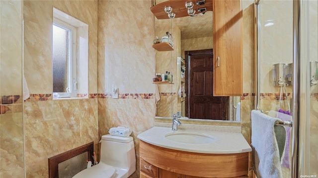 bathroom featuring vanity, toilet, and tile walls