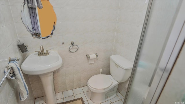 bathroom with tile patterned floors, sink, toilet, and tile walls