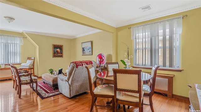 dining space with crown molding and hardwood / wood-style flooring