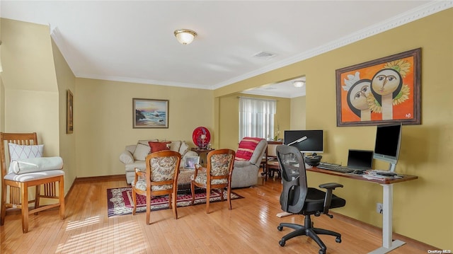 office area with light wood-type flooring and ornamental molding