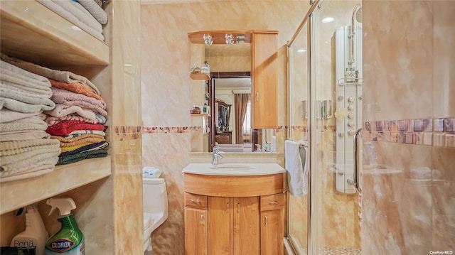 bathroom featuring vanity, a shower with shower door, and toilet