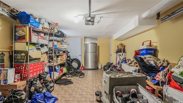 garage with stainless steel fridge and a garage door opener